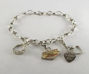 Silver charm bracelet with three pendants.