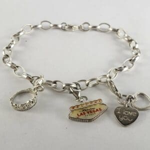 Silver charm bracelet with three pendants.