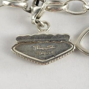 Silver bracelet charm with engraved details.