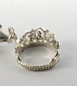 Silver crown-shaped ring on white background.