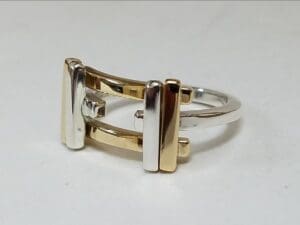 Two-tone metal ring with geometric design.