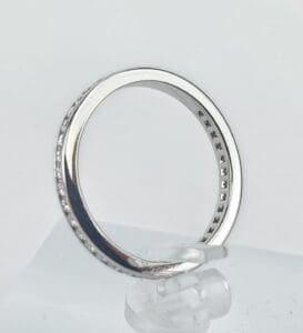 Silver diamond-studded ring on display stand.