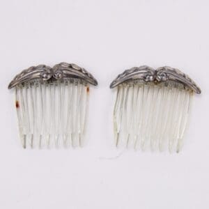 Two vintage hair combs with ornate tops.