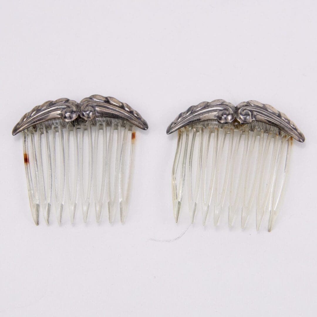 Two vintage hair combs with ornate tops.