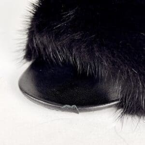 Black furry shoe with flat sole.