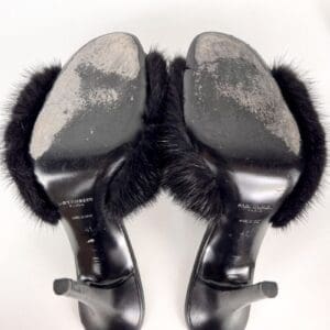 Worn high-heeled shoes with fur detail.