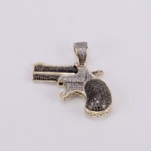 Gun-shaped pendant with black and white stones.