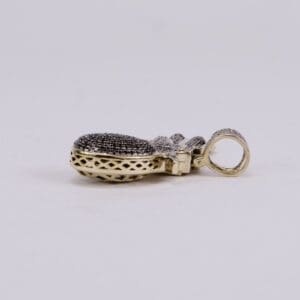 Gold and diamond pendant on side view.
