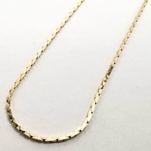 Gold chain necklace with textured links.
