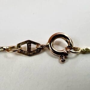 Gold bracelet clasp on a white background.