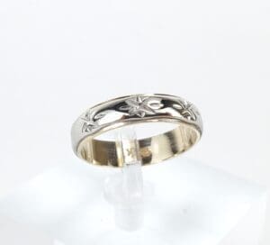 Silver ring with star pattern design.