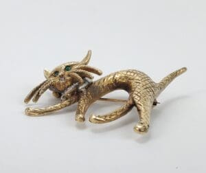 Gold cat brooch with green eyes.