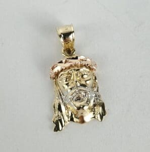 Gold Jesus face pendant with crown detail.