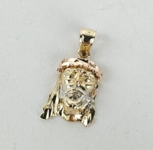 Gold pendant with a face design.