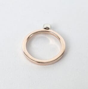 Gold ring with small silver attachment.