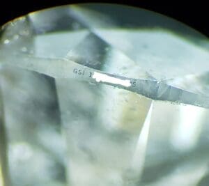 Close-up of a diamond with engraved text.