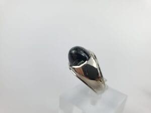 Silver ring with black oval gemstone.