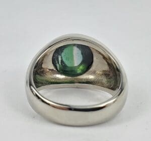 Silver ring with green gemstone centerpiece.