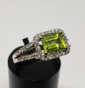 Silver ring with green gemstone and diamonds.