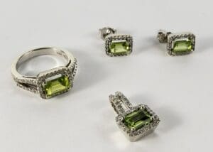 Silver jewelry set with green gemstones.