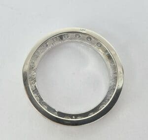 Silver ring with decorative engravings on surface.