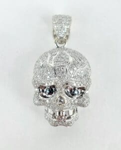 Diamond-encrusted skull pendant on white background.
