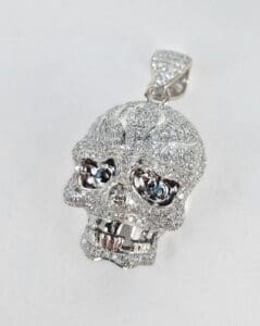 Diamond-encrusted skull pendant on white background.