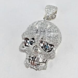 Diamond-encrusted skull pendant on white background.