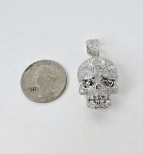 Skull pendant beside a quarter coin.