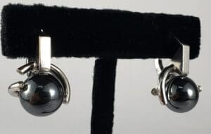 Silver earrings with black spherical stones.