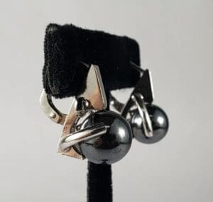 Silver earrings with black spherical accents.