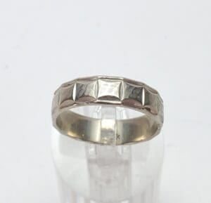 Silver ring with geometric pattern design.