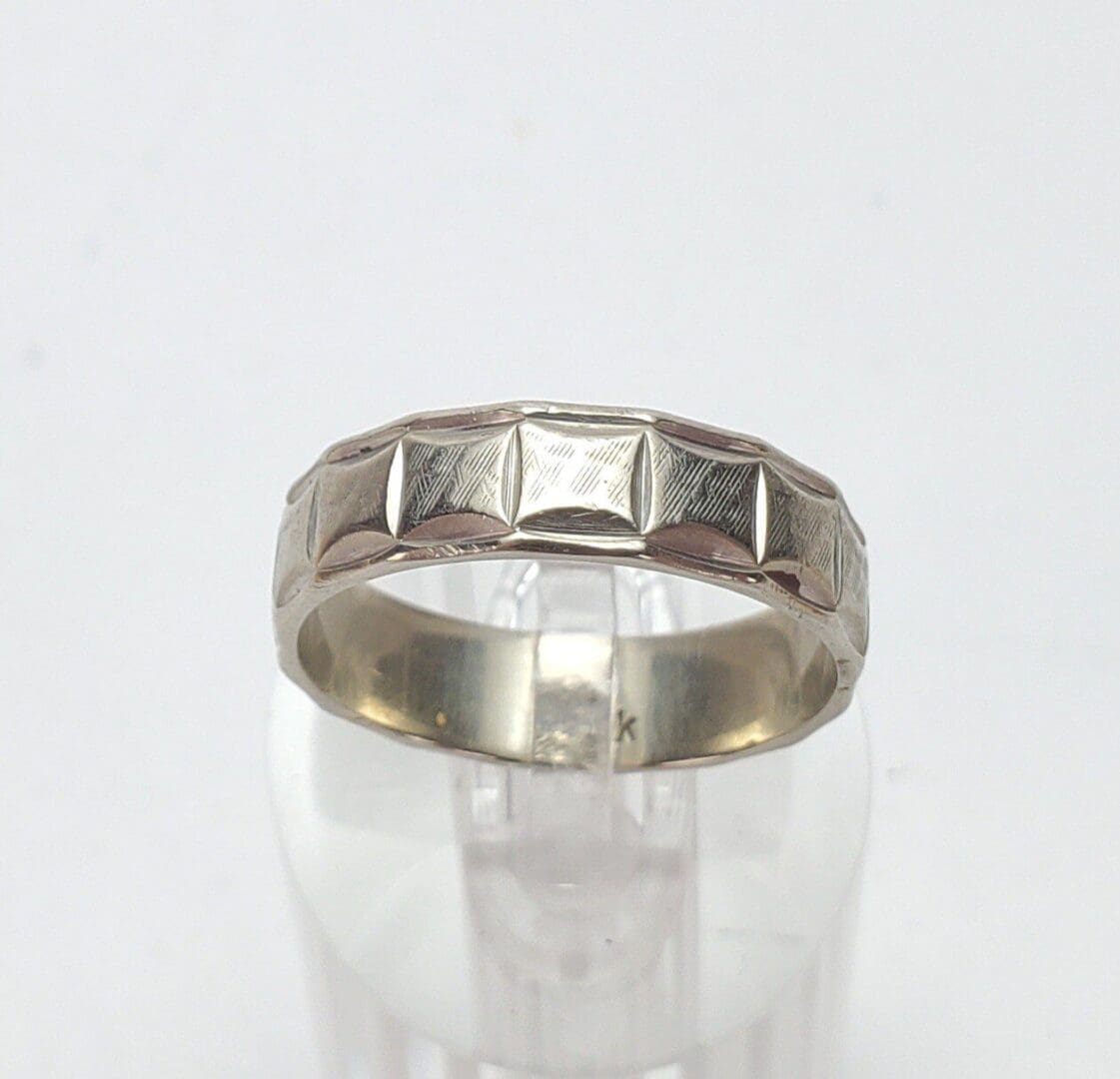 Silver ring with geometric pattern design.