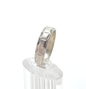 Silver ring with geometric pattern design.