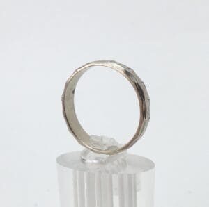 Silver ring with faceted design on display.