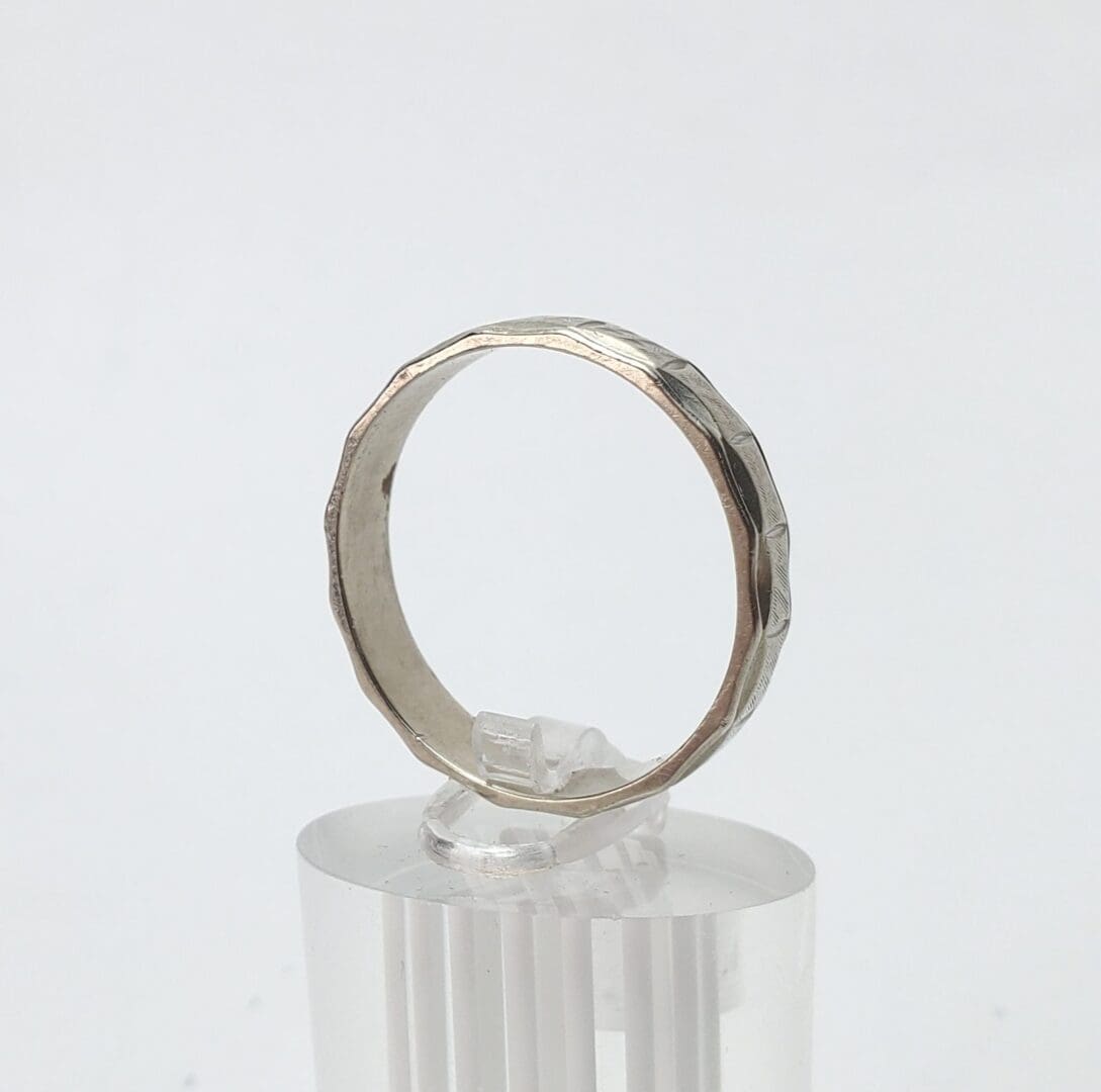 Silver ring with faceted design on display.