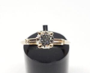 Gold ring with a round diamond centerpiece.