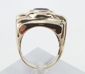 Gold ring with purple gemstone, side view.