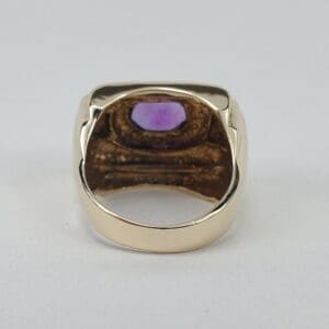 Gold ring with purple gemstone inside view.