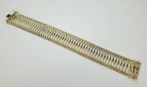 Gold braided bracelet on white background.