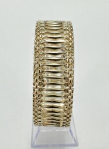 Gold bracelet with intricate woven design.