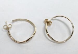 Gold hoop earrings on white background.
