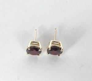 Gold stud earrings with red gemstones.