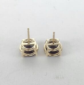 Gold stud earrings with round gemstones.