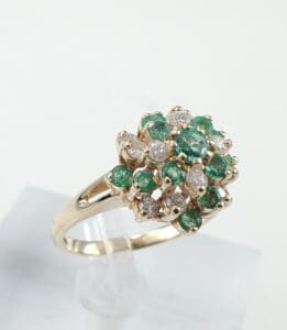 Gold ring with emerald and diamond cluster.