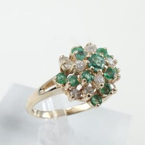 Gold ring with emerald and diamond cluster.