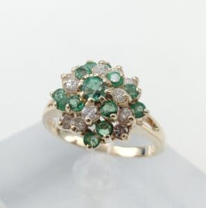 Gold ring with emeralds and diamonds cluster.