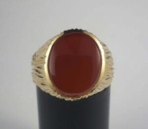 Gold ring with large red gemstone.