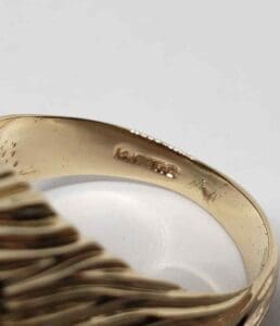 Gold ring with engraved text inside band.