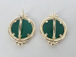 Gold earrings with green circular stones.